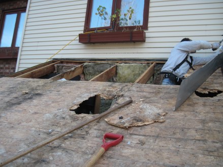 OSB damaged by persistent leakage, being removed.  Note the dark stains in the insulation.  It too will be removed.